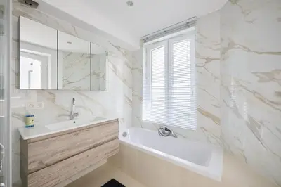 a bathroom with a tub and a sink and a mirror at Toison d'Or & Sauna in Brussels