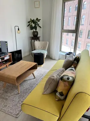a living room with a yellow couch and a table at TML Riverside Appartment 2 Bedrooms in Boom