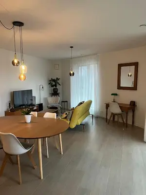 a living room with a table and yellow chairs at TML Riverside Appartment 2 Bedrooms in Boom
