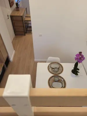 a table with a plate and a vase of flowers at Studio Saintes-Catherine in Brussels