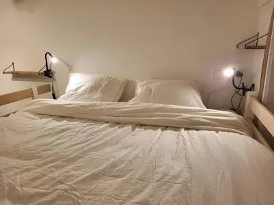 a white bed with white sheets and pillows at Studio Saintes-Catherine in Brussels