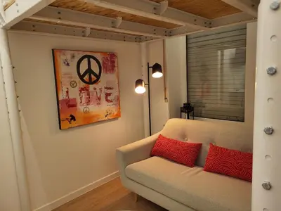 a living room with a couch and a painting on the wall at Studio Saintes-Catherine in Brussels