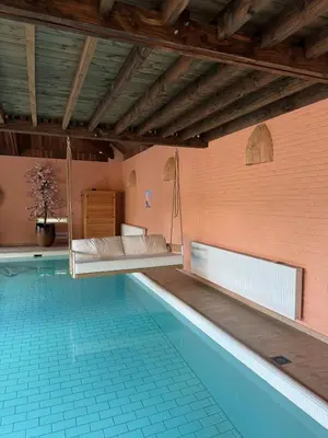 a room with a hanging bed and a swimming pool at Sensi Waters in Duffel