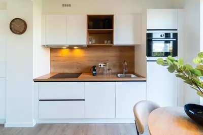 a kitchen with white cabinets and a sink at Fourstay Luxury City Apartments Diegem - Brussels in Diegem