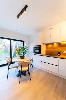 a kitchen with white cabinets and a table and chairs at Fourstay Luxury City Apartments Diegem - Brussels in Diegem