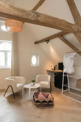a living room with two chairs and a table at NOX Logies, vakantiewoning en polyvalente ruimte in Grimbergen