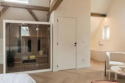 a bedroom with a glass door leading to a bathroom at NOX Logies, vakantiewoning en polyvalente ruimte in Grimbergen