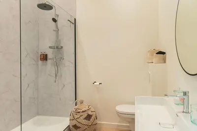 a bathroom with a shower and a toilet and a sink at NOX Logies, vakantiewoning en polyvalente ruimte in Grimbergen