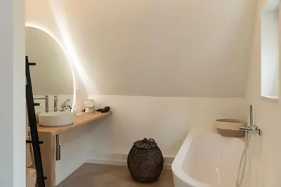 a bathroom with a sink and a toilet and a mirror at NOX Logies, vakantiewoning en polyvalente ruimte in Grimbergen
