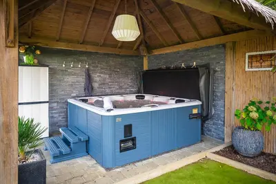 a blue bath tub sitting under a roof at Stijl en kleur in Diest
