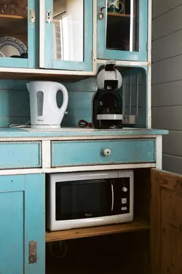 a microwave in a blue cabinet in a kitchen at Stijl en kleur in Diest
