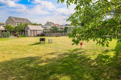 a yard with a field of green grass with houses at Stijl en kleur in Diest