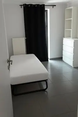 a white bed in a room with a black curtain at Apartment Boom 200m from centrm in Boom
