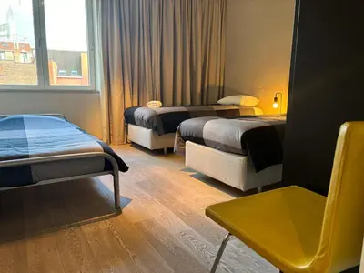 a hotel room with two beds and a window at Charming apartment in the Heart of Brussels in Brussels