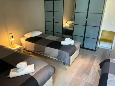 a hotel room with two beds and a mirror at Charming apartment in the Heart of Brussels in Brussels