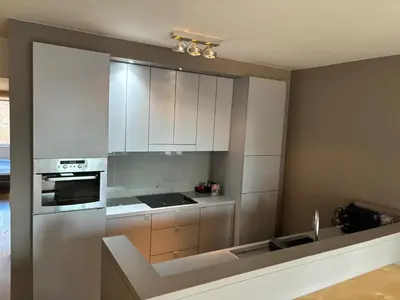 a kitchen with white cabinets and a stove top oven at Charming apartment in the Heart of Brussels in Brussels