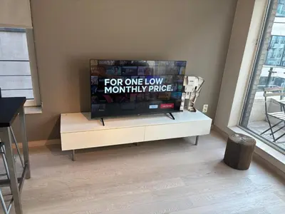 a flat screen tv sitting on top of a white cabinet at Charming apartment in the Heart of Brussels in Brussels