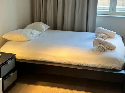 a bed with towels on top of it with a window at Charming apartment in the Heart of Brussels in Brussels