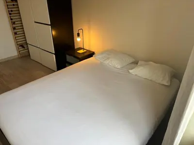 a bedroom with a large white bed and a lamp at Charming apartment in the Heart of Brussels in Brussels