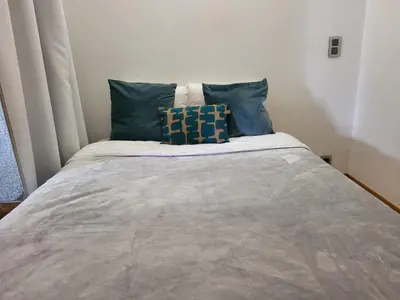 a bed with two blue pillows on top of it at Nice studio EU Quarter in Brussels