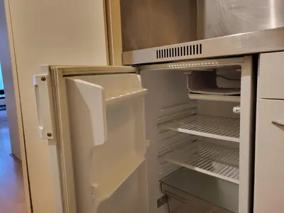 an empty refrigerator with its door open in a kitchen at Nice studio EU Quarter in Brussels