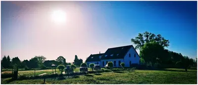 a white house with a black roof in a field at B&B Heinehoeve in Kaprijke