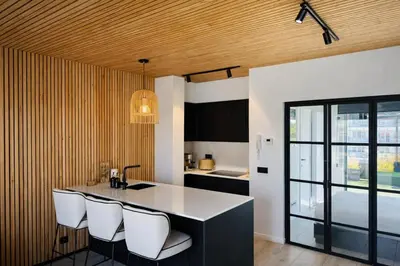 a kitchen with a island with white chairs in it at Stylish Penthouse in BXL with 2 Panoramic Terraces in Brussels
