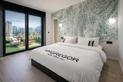 a bedroom with a large white bed with a window at Stylish Penthouse in BXL with 2 Panoramic Terraces in Brussels