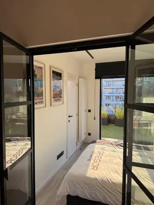 a bedroom with a bed and a glass wall at Stylish Penthouse in BXL with 2 Panoramic Terraces in Brussels