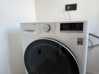 a white washing machine sitting in a room at Stylish Penthouse in BXL with 2 Panoramic Terraces in Brussels