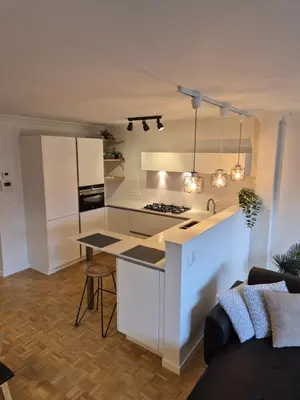 a kitchen with white cabinets and a counter top at Huis ALNA 7 in Mechelen