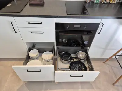 an open kitchen drawer with dishes and utensils at Huis ALNA 7 in Mechelen