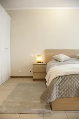 a bedroom with a bed and a night stand with a lamp at Sunny Stay & Chill in Brussels