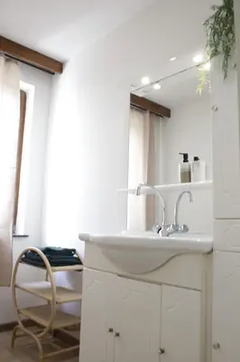 a bathroom with a sink and a chair and a mirror at Sunny Stay & Chill in Brussels