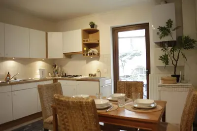 a kitchen with a wooden table with chairs and a dining room at Sunny Stay & Chill in Brussels