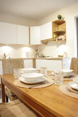 a wooden table with plates and glasses on it in a kitchen at Sunny Stay & Chill in Brussels