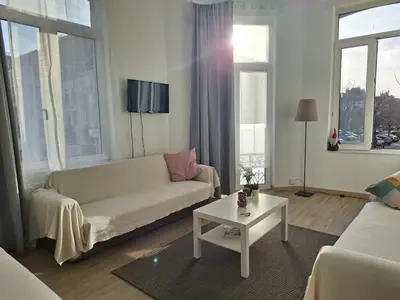 a living room with a white couch and a table at Midi Gateway in Brussels