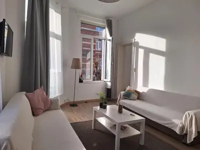 a living room with two white couches and a table at Midi Gateway in Brussels