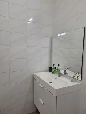 a white bathroom with a sink and a mirror at Midi Gateway in Brussels