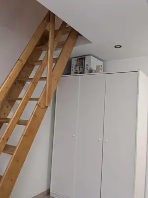 a loft conversion with white cabinets and a ladder at Full apartment near Brussels and Zaventem in Vilvoorde