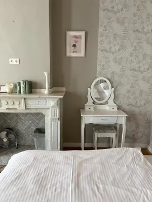 a bedroom with a bed and a table with a mirror at cosy studio in Antwerp