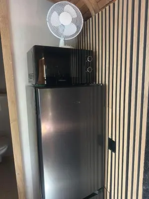a microwave sitting on top of a refrigerator at PipoParel in Ravels