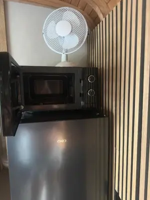 a microwave on top of a refrigerator with a fan at PipoParel in Ravels