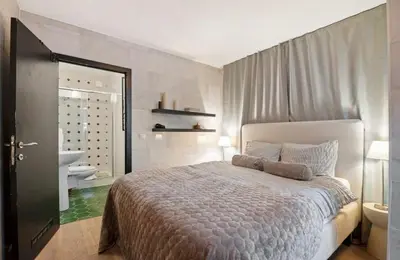 a bedroom with a large bed and a bathroom at Boutique apartment Antwerp in Antwerp