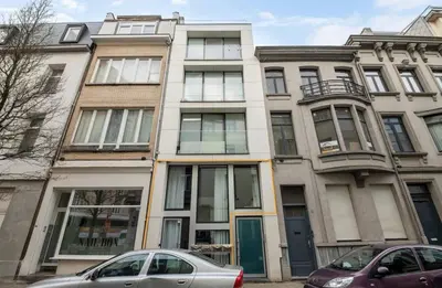 an apartment building with cars parked in front of it at Boutique apartment Antwerp in Antwerp