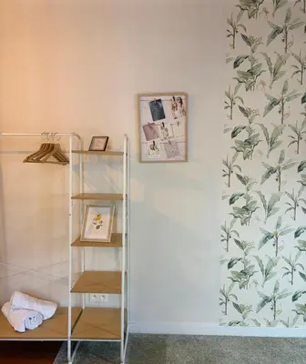 a shelf in a room with a wall with a wallpaper at cosy studio2 in Antwerp