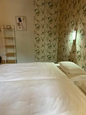 a white bed in a bedroom with a wallpaper at cosy studio2 in Antwerp