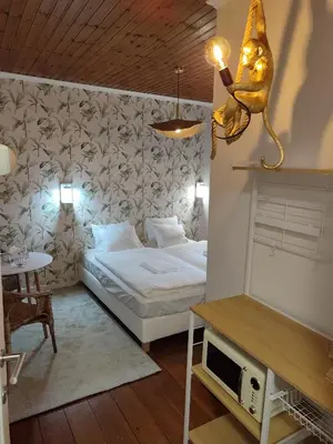 a bedroom with a white bed and a table and a tableablish at cosy studio2 in Antwerp