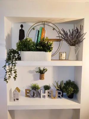 a shelf with plants and a sign that reads home at Sweet cozy studio in Antwerp