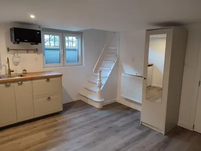 a kitchen with a staircase and a sink and a room at Sweet cozy studio in Antwerp
